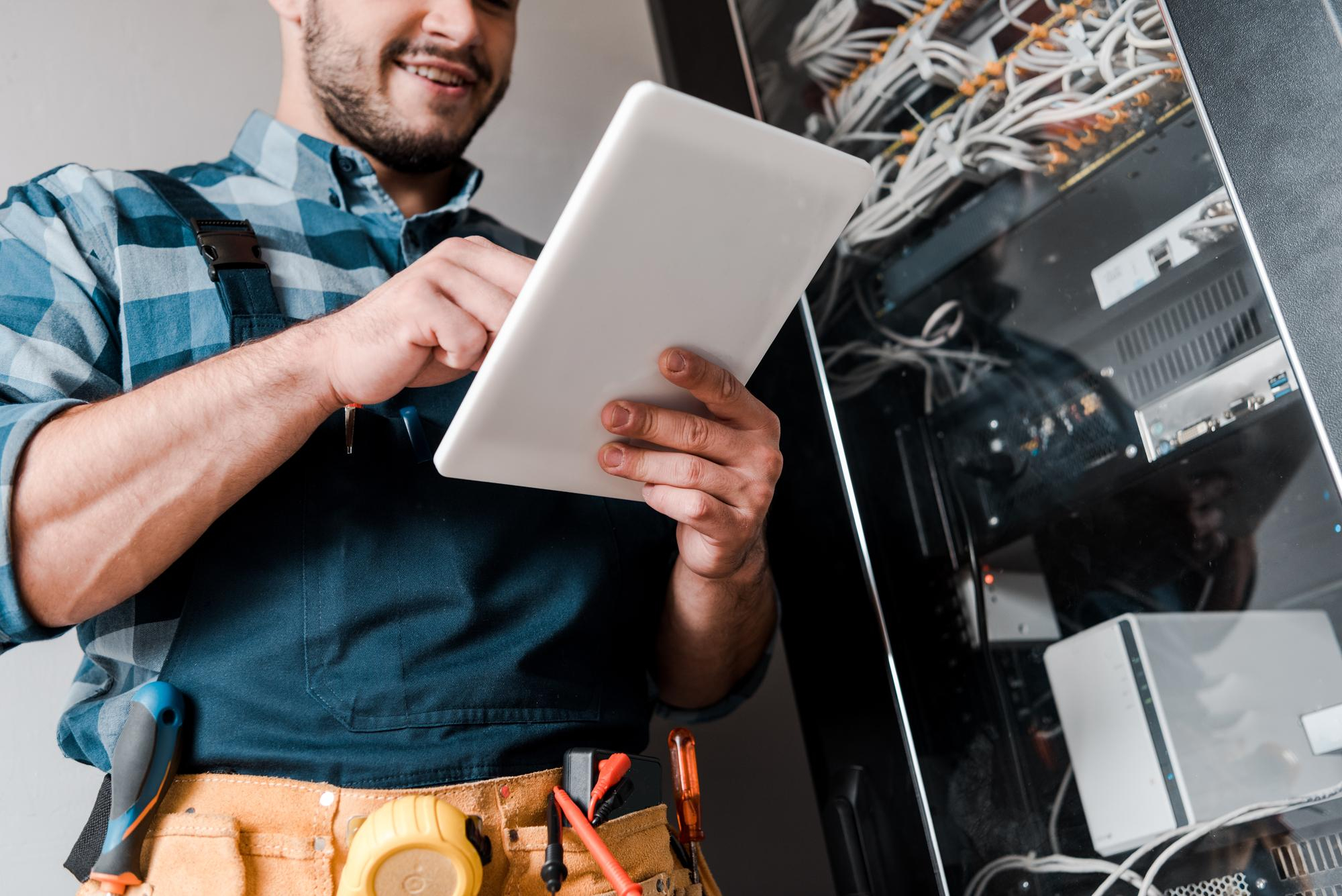 Technical engineer managing mission critical data centre infrastructure using digital maintenance and commissioning tools