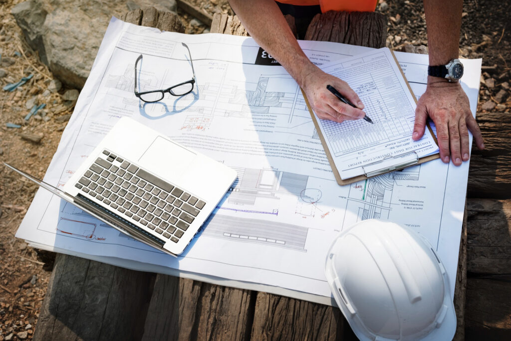 Technical project manager reviewing construction plans and quality documentation for mission critical infrastructure projects
