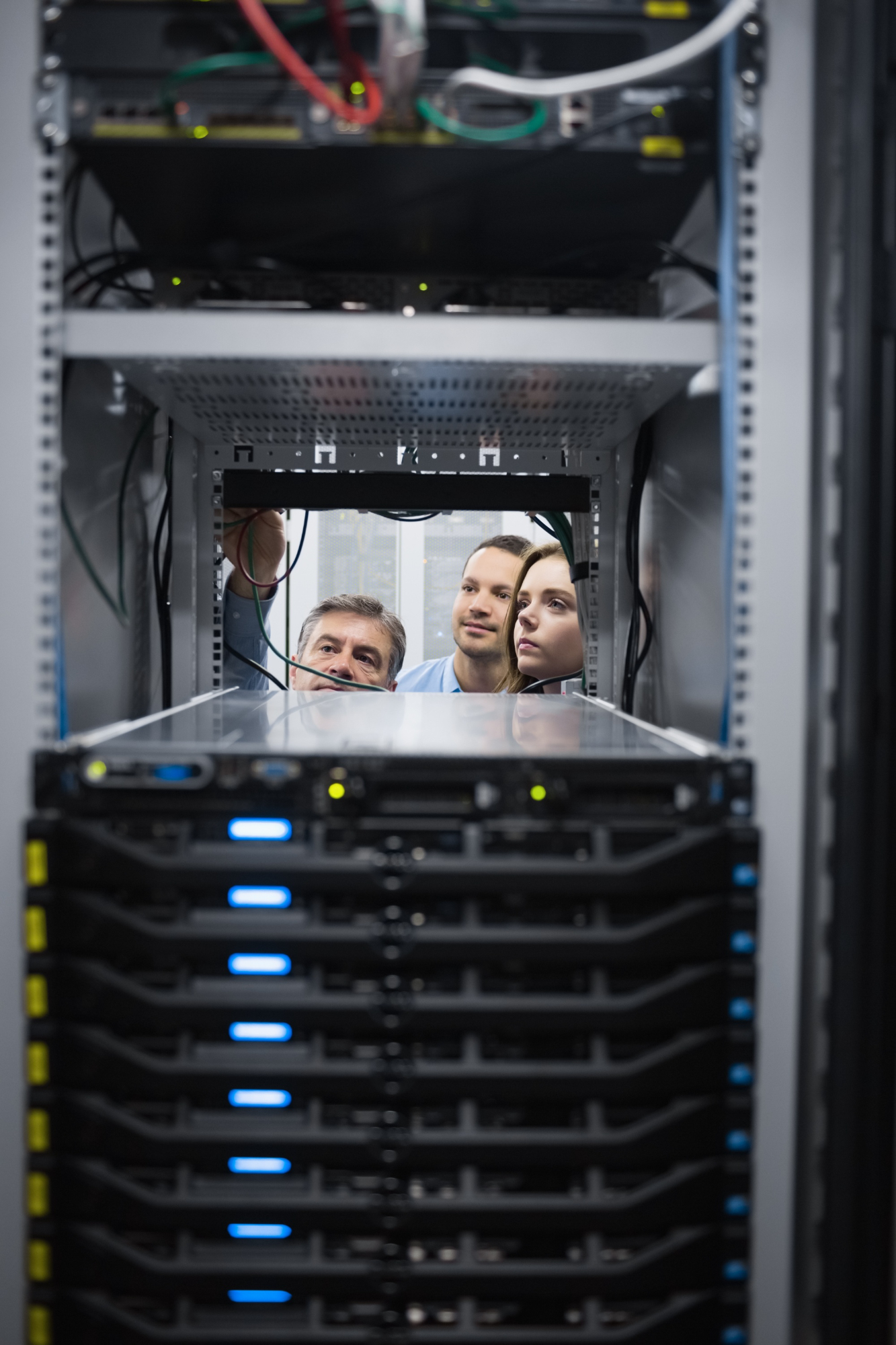 Technical specialists inspecting enterprise server infrastructure during data centre commissioning and system validation